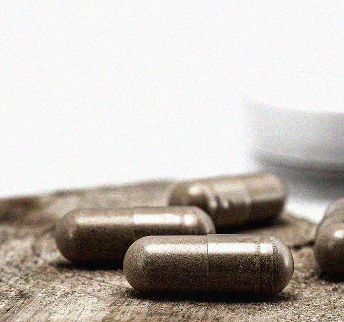 Brown supplement capsules from BorealPotions laying on a wooden table